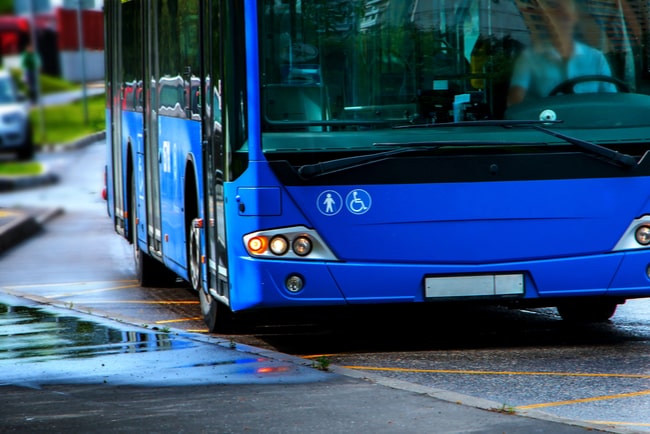 blå buss bromsar in vid busshållplats