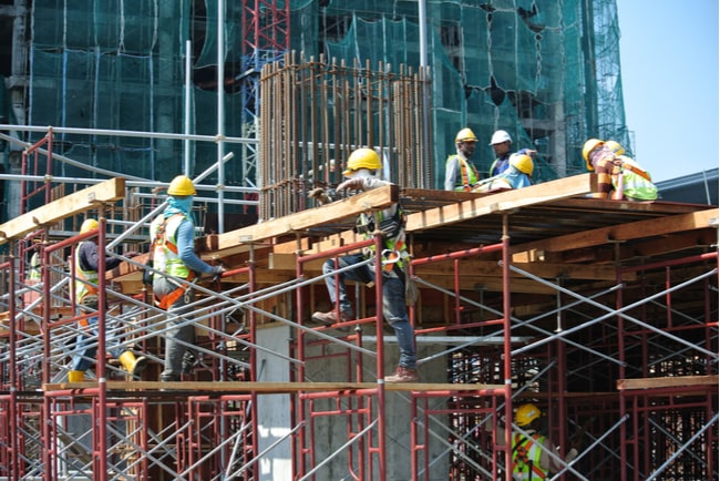 Byggarbetare på arbetsplats som är utrustade med säkerhetsutrustning