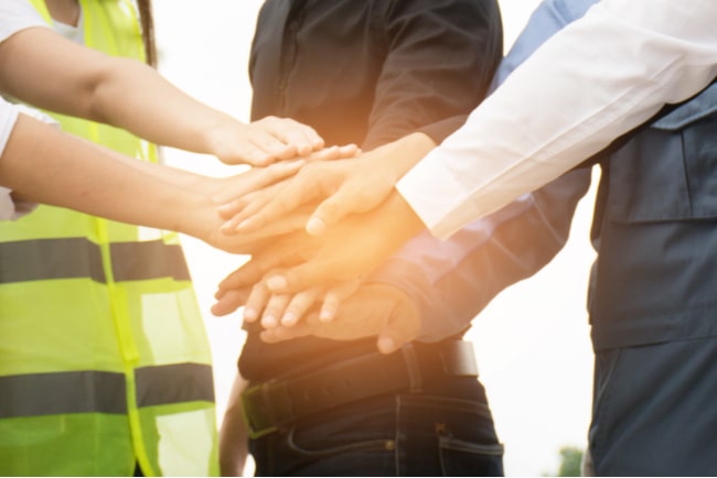 affärsmän och arbetare räcker varandra händerna för gott samarbete