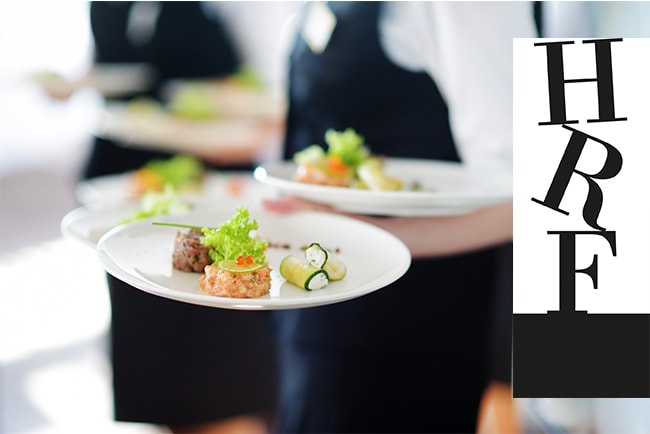 suddig bild på servitörer som håller i tallrikar med mat och hrf:s logga i svart/vitt