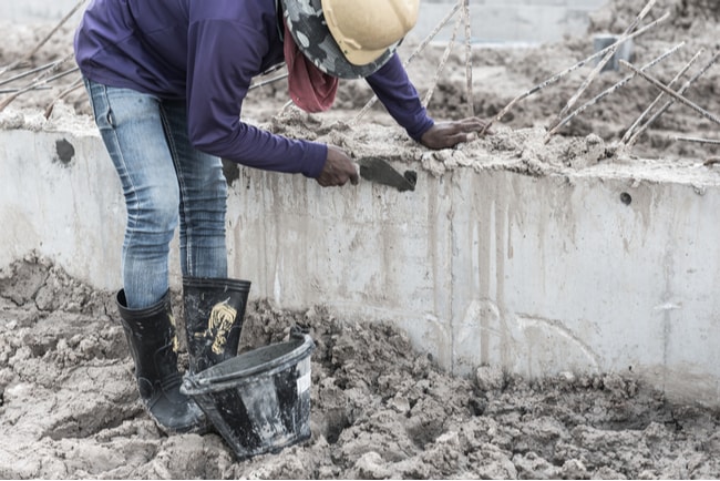 arbetare skrapar en betonggrund
